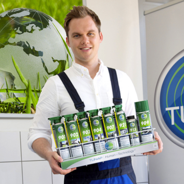 Man smiling holding dynamic engine cleaning products from Tunap.